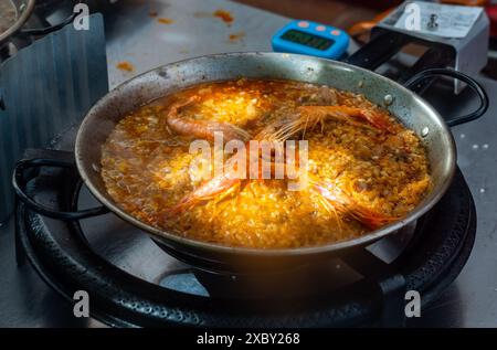 Processus de cuisson de paella de fruits de mer dans une grande poêle à frire Banque D'Images