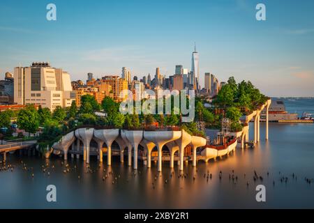 Longue exposition de Little Island au-dessus de la rivière Hudson à Chelsea, New York, avec la ligne d'horizon inférieure de Manhattan comme toile de fond magnifique au crépuscule. Banque D'Images