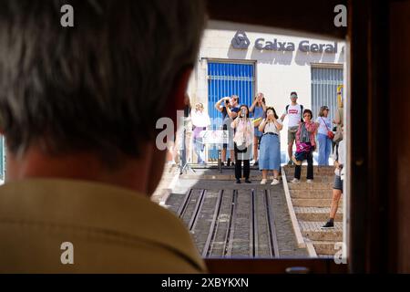 Lisbonne, Portugal mai 29 2024 : vue depuis le taxi du funiculaire Ascensor da Bica sur les touristes prenant des photos avec leurs smartphones Banque D'Images