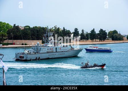 Brindisi, Italie. 13 juin 2024. Au cours du sommet, les autorités italiennes ont mis en place des niveaux de sécurité élevés dans toute la région des Pouilles en Italie. Un bateau militaire destroyer se trouve dans le port de Brindisi tandis qu'un bateau de la police maritime accélère et un bateau de tourisme passent. Le sommet du Groupe des sept (G7) est un forum économique et politique intergouvernemental composé du Japon, de l'Italie, du Canada, du Royaume-Uni, de Allemagne et États-Unis. Cette année, le sommet se tient en Italie. Crédit : SOPA images Limited/Alamy Live News Banque D'Images