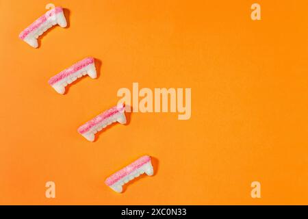 Bonbons de dents de vampire en gomme isolés sur fond orange, gâteries d'Halloween Banque D'Images