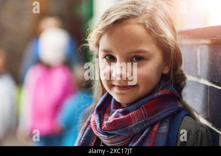 École primaire, couloir et portrait de fille avec le sourire pour l'éducation académique, l'érudition et le développement de l'enfant. Heureux, visage et gosse dans le couloir Banque D'Images