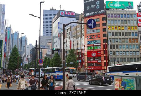 Les embouteillages et les foules de piétons créent une scène animée et dynamique sur Koshu-kaido Avenue Nishishinjuku, Tokyo, Japon. Hôtel Park Hyatt en arrière-plan Banque D'Images