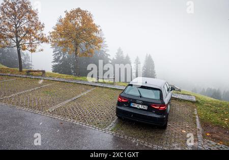 Noir Audi A3 hatchback garé sur un côté du col alpin avec des arbres d'automne en arrière-plan. Road trip à travers la campagne autrichienne. Banque D'Images