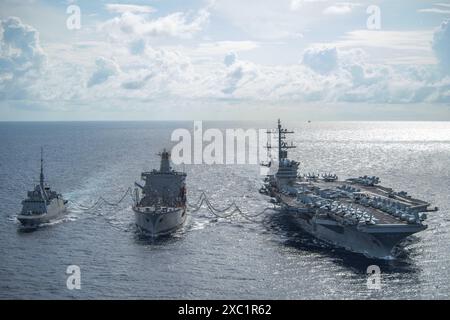 MER DE CHINE MÉRIDIONALE (6 juin 2024) le porte-avions de classe Nimitz USS Theodore Roosevelt (CVN 71), à droite, effectue un ravitaillement en mer avec l'armée Banque D'Images