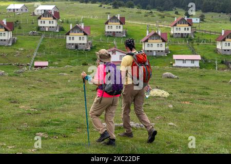 Couple sur trekking et Kasimlar plateau maisons en arrière-plan, Kizilcahamam, Ankara, Turquie Banque D'Images