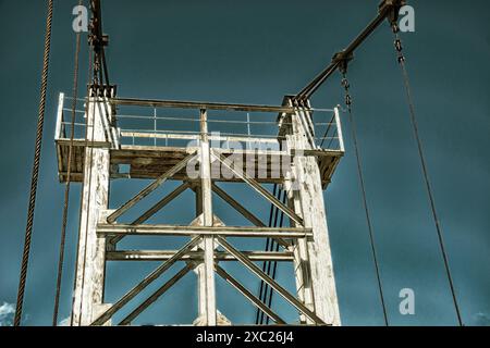 Image sombre de la vieille tour métallique de pont sous le ciel crépusculaire. Constructions industrielles Banque D'Images