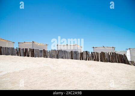 Tentes blanches sur le sable d'une plage déserte Banque D'Images