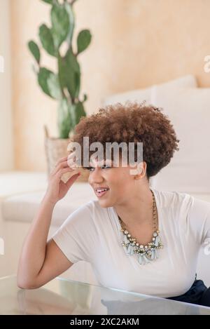 Femmes noires avec afro regardant sur le côté et cactus derrière Banque D'Images