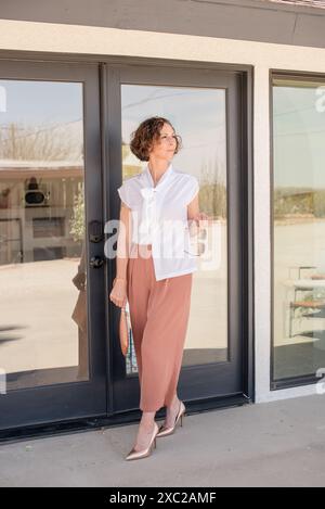 Femmes à la mode marchant dehors dans le désert tenant des lunettes de soleil Banque D'Images