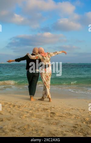 Femmes musulmanes en hijab profitant du temps libre à la plage Banque D'Images