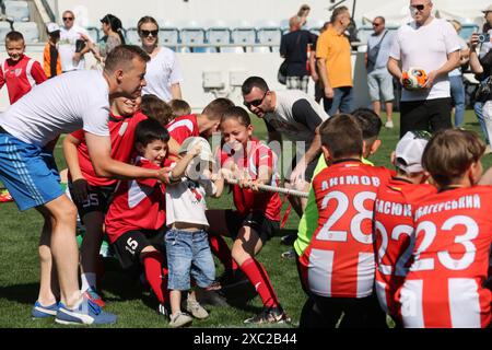 ODESSA, UKRAINE, 9 juin 2024 : des équipes d'enfants jouent à la guerre lors d'un festival sportif. Combat d'équipe sportive - remorqueur de guerre sur l'herbe verte de la pelouse du stade. Chi Banque D'Images