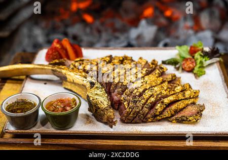 Tomahawk de bœuf de qualité supérieure enrobé d'or comestible Banque D'Images