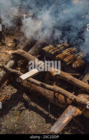 Nourriture cuite sur un feu de joie sur le gril sur un feu ouvert. Banque D'Images