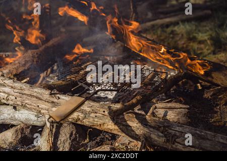 Nourriture cuite sur un feu de joie sur le gril sur un feu ouvert. Banque D'Images