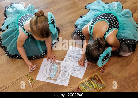 Deux jeunes filles vêtues de costumes colorant ensemble Banque D'Images