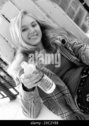 Adolescente cente caucasienne tenant une bouteille d'eau, USA. Banque D'Images