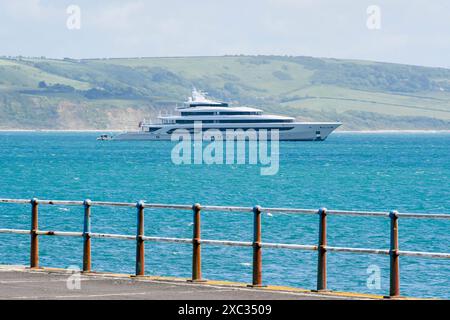 Weymouth, Dorset, Royaume-Uni. 14 juin 2024. Le superyacht H3 (anciennement Indian Empress) est ancré au large de la côte à Weymouth dans le Dorset depuis deux jours. Le superyacht appartient à l'homme d'affaires milliardaire saoudien Waleed bin Ibrahim Al Ibrahim, fondateur et président du Middle East Broadcasting Centre, également connu sous le nom de MBC Group. Le yacht nommé d'après l'épouse du propriétaire, Hana a été construit par Oceanco aux pays-Bas en 2000. H3, est classé au numéro 74 dans le classement mondial des plus grands yachts. Crédit photo : Graham Hunt/Alamy Live News Banque D'Images