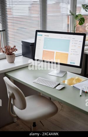 PC de bureau propre et minimaliste avec écran lumineux affichant la plate-forme de cours en ligne. Cadre confortable et espace de travail productif Banque D'Images