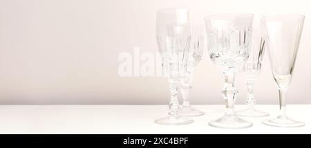 Bannière avec des verres en cristal devant un fond beige. Banque D'Images