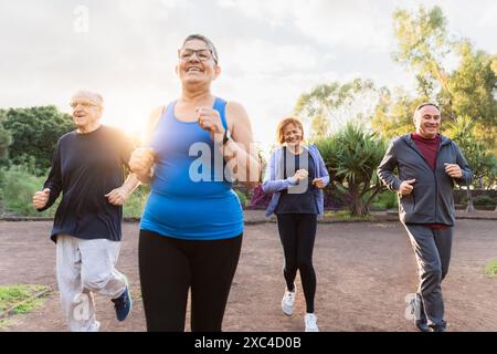 Groupe de personnes âgées diverses jogging ensemble au parc Banque D'Images