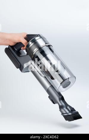 Aspirateur sans fil avec brosse à poussière vue latérale dans la main isolé sur fond blanc de studio Banque D'Images