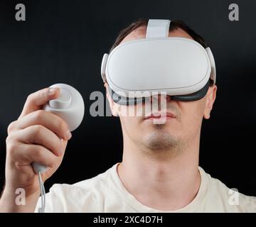 Portrait de l'homme jouant en réalité virtuelle vue de face isolé sur fond noir de studio Banque D'Images