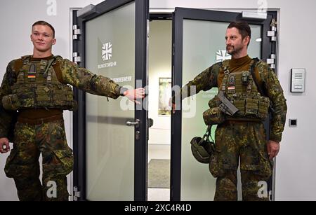 Erfurt, Allemagne. 14 juin 2024. Deux soldats de la 4e compagnie du bataillon de chars 393 de Bad Frankenhausen se tiennent devant la porte du Centre de carrière de la Bundeswehr à Erfurt le jour de l'ouverture. Depuis avril 2024, les bureaux de conseil en carrière de la Bundeswehr dans les états fédéraux de Thuringe et de Saxe sont sous le contrôle du Centre de carrière de la Bundeswehr (KarrCBw) Erfurt. Les tests de recrutement pour les candidats des deux états fédéraux ont désormais lieu également dans ce pays. Crédit : Martin Schutt/dpa/Alamy Live News Banque D'Images