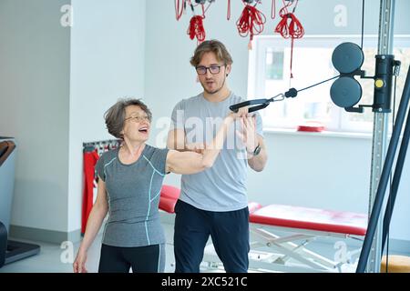 Le patient âgé effectue des exercices pour renforcer les muscles Banque D'Images