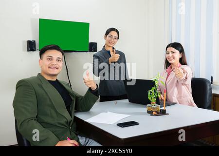 une équipe de bureau d'homme et de femme d'affaires devant un écran vert dans une table de réunion discutant Banque D'Images