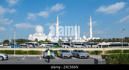 Abu Dhabi, Émirats arabes Unis - 4 janvier 2024 : la Grande Mosquée Sheikh Zayed se dresse resplendissante contre le ciel bleu, vue depuis le parking touristique. Banque D'Images