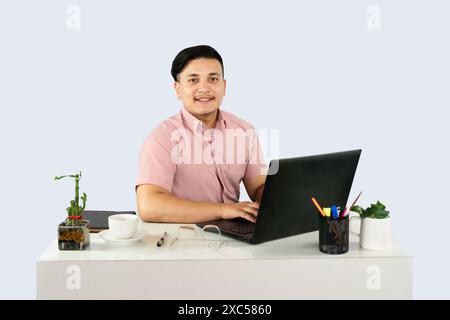 Réception homme réceptionniste entrepreneur d'affaires avec appareil mobile ordinateur portable et bloc-notes donne des expressions et des gestes de heureux dans l'environnement de bureau Banque D'Images