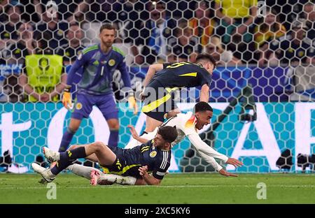 L'écossais Ryan Christie concède une pénalité pour une faute sur l'Allemand Jamal Musiala avant qu'elle ne soit changée en coup franc après un contrôle VAR lors du match du Groupe A De l'UEFA Euro 2024 au Munich Football Arena, en Allemagne. Date de la photo : vendredi 14 juin 2024. Banque D'Images