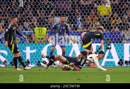 L'écossais Ryan Christie concède une pénalité pour une faute sur l'Allemand Jamal Musiala avant qu'elle ne soit changée en coup franc après un contrôle VAR lors du match du Groupe A De l'UEFA Euro 2024 au Munich Football Arena, en Allemagne. Date de la photo : vendredi 14 juin 2024. Banque D'Images