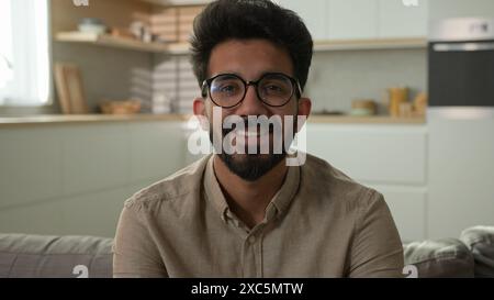 Portrait souriant Indien arabe musulman moyen-Orient homme heureux millennial Guy propriétaire d'une maison seul sur le canapé se détendre sur le canapé dans la cuisine loueur masculin propre Banque D'Images