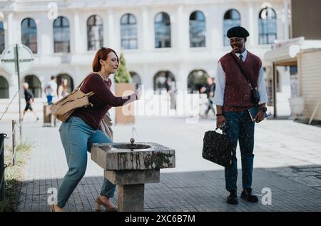 Rencontre d'affaires décontractée à une fontaine d'eau urbaine pendant une journée ensoleillée Banque D'Images