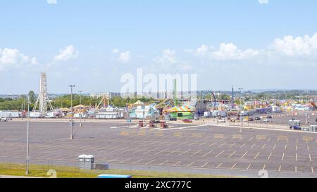 Parc d'attractions avec grandes roues et montagnes russes sous un ciel bleu avec des nuages blancs New York NY USA 2023-07-30 Banque D'Images