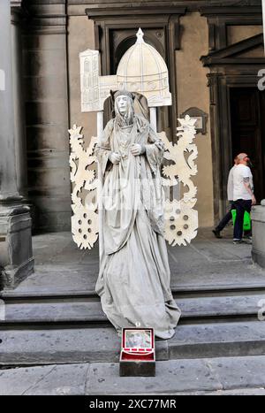 Artiste de rue en costume comme une statue devant des bâtiments historiques avec des passants en arrière-plan, Florence, site du patrimoine mondial de l'UNESCO Banque D'Images