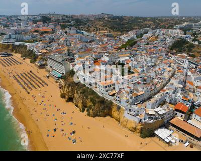 Ville sur une colline avec une plage de sable animée sur la côte et de nombreux bâtiments, vue aérienne, Albufeira, Faro, Algarve, Portugal Banque D'Images