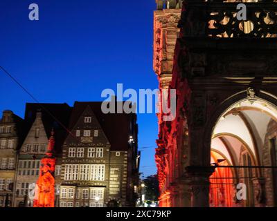 Bâtiments historiques et rues la nuit, illuminés par des lumières rouges et entourés par un ciel sombre, Brême, Allemagne Banque D'Images