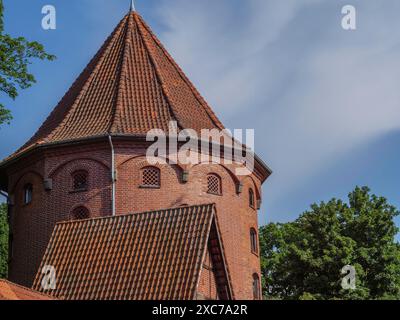 Tour de briques historique avec toit pointu, entouré d'arbres, détails architecturaux clairs contre un ciel bleu, gothmund, travemuende, luebeck, allemagne Banque D'Images