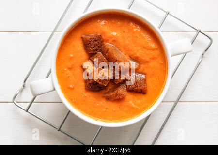 Pot de soupe à la crème savoureuse avec des croûtons sur fond de bois blanc Banque D'Images