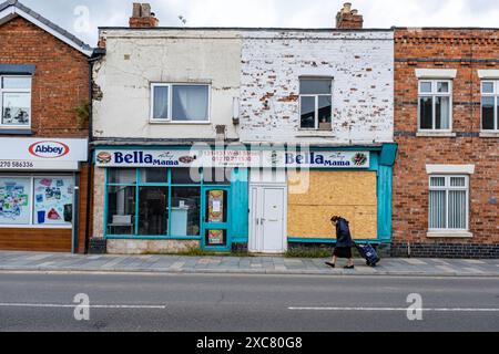 Senior Woman Passing a fermé ses portes et a embarqué sur Bella Mama Takeaway à Crewe Cheshire UK Banque D'Images