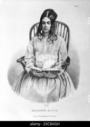 Gravure en noir et blanc d'une jeune femme assise sur une chaise, tenant une Bible sur ses genoux. Ses yeux sont fermés, et son expression est celle de la pensée profonde. La gravure est intitulée Mania religieuse. C'est une représentation d'un patient souffrant de manie religieuse, comme illustré dans le Medical Times Gazette. Banque D'Images