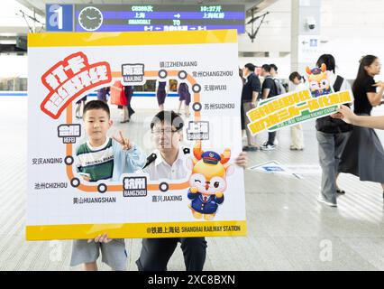 (240615) -- SHANGHAI, 15 juin 2024 (Xinhua) -- Un enfant pose pour des photos avant de monter à bord du train G8388 à la gare de Shanghai dans l'est de la Chine Shanghai, le 15 juin 2024. Le delta du fleuve Yangtsé, une région économiquement dynamique en Chine, a vu samedi l'exploitation de sa première ligne de boucle de chemin de fer, reliant la métropole de Shanghai avec les grandes villes du cluster régional. Codé G8388, le premier service de train sur le chemin de fer de boucle a été lancé à partir de la gare de Shanghai à 10h27 samedi. Pour une boucle complète, le train est prévu pour un trajet de huit heures et neuf minutes sur un Banque D'Images