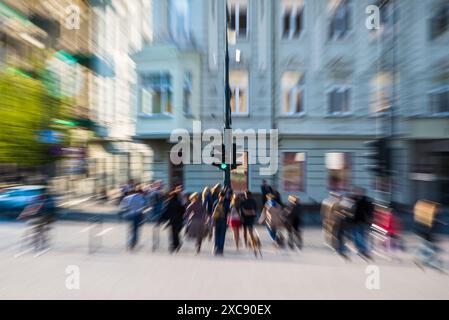 Les gens traversent la rue dans Une ville animée avec le zoom créatif et l'effet de mouvement créé par caméra Banque D'Images