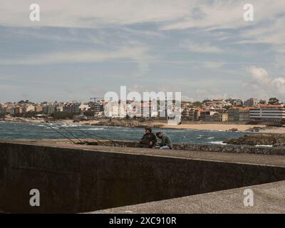 Deux pêcheurs assis sur un quai à Foz do Douro Porto.Portugal.27.05.2024 Banque D'Images