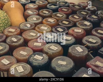 Bocaux en verre avec différents types de confiture délicieuse naturelle pour fromage sur un stand de marché Banque D'Images