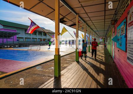 Match de football dans l'école du village de pêcheurs flottant de Koh Panyee fait de maisons sur pilotis dans la baie de Phang Nga, mer d'Andaman, Thaïlande Banque D'Images