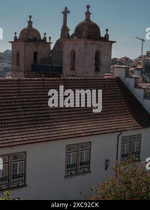 Vue sur le paysage urbain le sommet des cathédrales médiévales et les bâtiments traditionnels anciens colorés avec des toits de tuiles rouges dans le quartier de Ribeira à Porto Banque D'Images